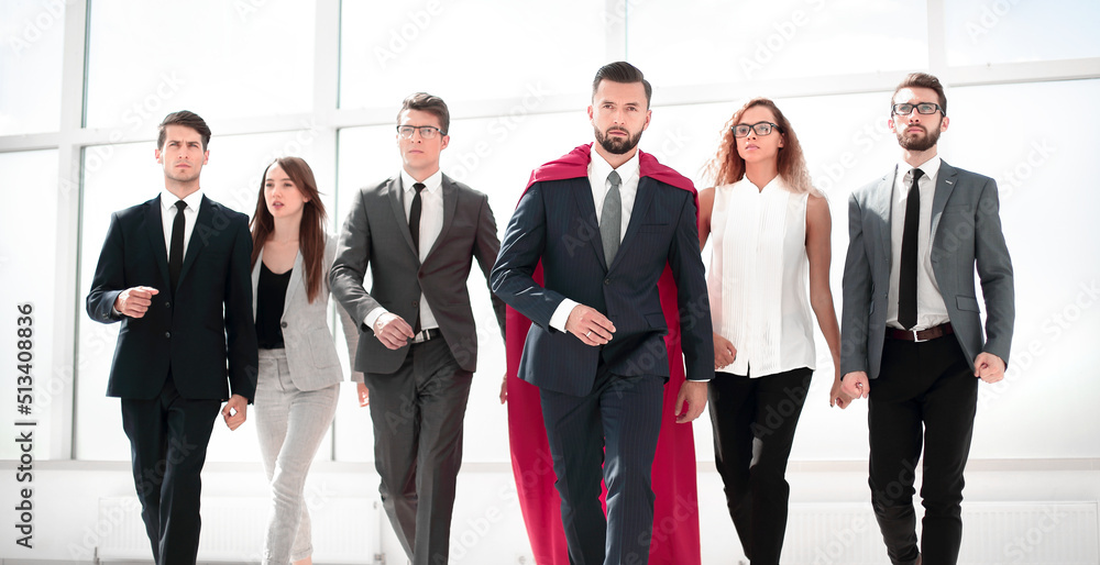 businessman in a red superhero cloak and his business team