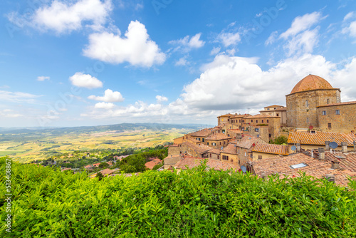View of the colorful hills of Tuscany and the medieval hilltop town of Volterra, Italy, with the duomo and city walls in view Fototapet