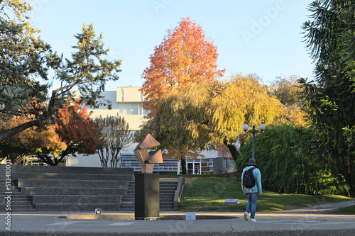 Unrecognizable students walking on the campus of University of Talca (Chile) during autumn sunny afternoon