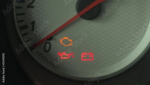 The warning lights on the car dashboard come on. Close-up.