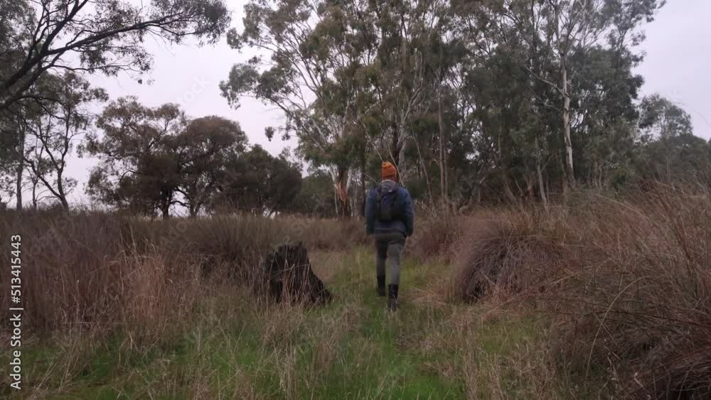 A fisherman walks through scrub and bush in the Wimmera on a dry creek bed with a fishing rod in his backpack. A fisherman walks through scrub and bush in the Wimmera on a dry creek bed with a fishing rod in his backpack.