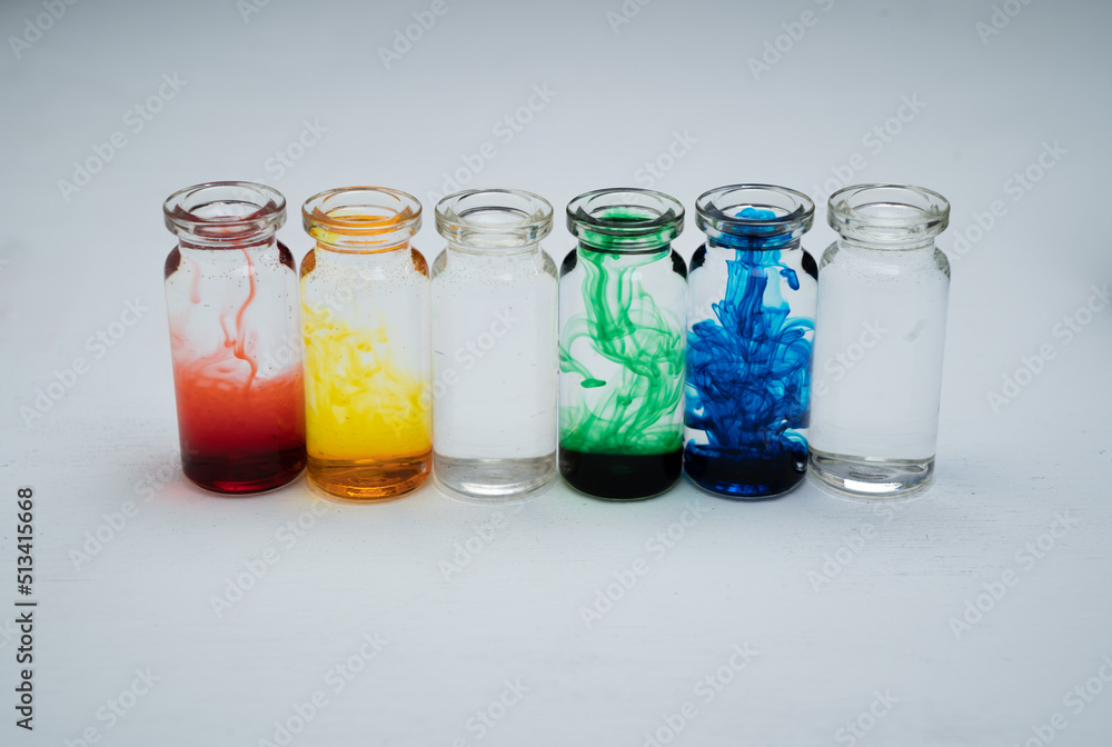 seis botellitas de vidrio con tintas diluidas multicolor y fondo blanco - obrazy, fototapety, plakaty 