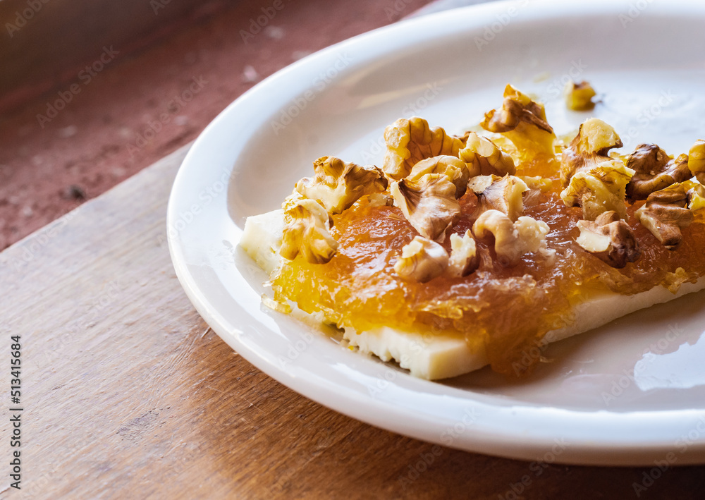 Handmade fibrous cayote or alcayota (Cucurbita ficifolia) jam with quesillo (homemade cheese) and nuts as a topping. Typical dessert from the Northwest Region of Argentina. Handmade fibrous cayote or alcayota (Cucurbita ficifolia) jam with quesillo (homemade cheese) and nuts as a topping. Typical dessert from the Northwest Region of Argentina.