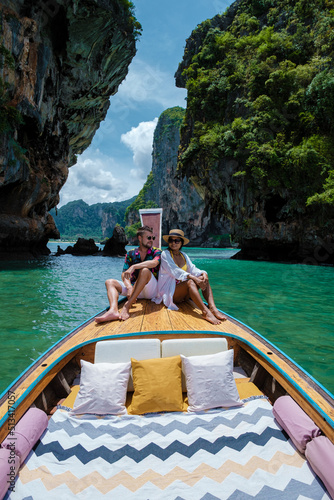 Luxury Longtail boat in Krabi Thailand, couple man, and woman on a trip at the tropical island 4 Island trip in Krabi Thailand. Asian woman and European man mid age on vacation in Thailand.  photo