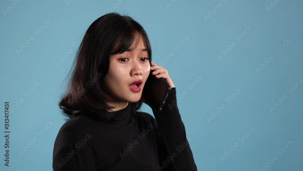 Beautiful woman interact with her phone over blue background Beautiful woman interact with her phone over blue background