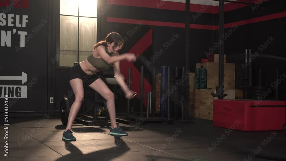 Young woman slim body training and working out with battle rope at fitness gym Young woman slim body training and working out with battle rope at fitness gym