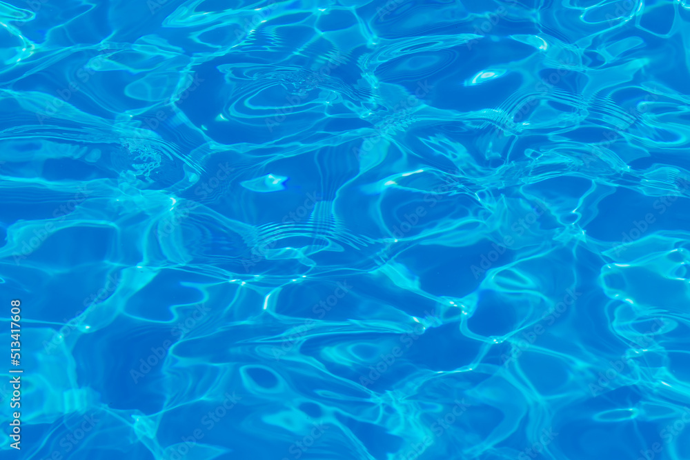 Swimming pool water surface with sparkling light reflections. Aqua background.