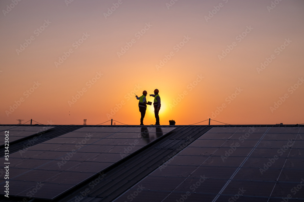 Engineers walking on roof inspect and check solar cell panel by hold ...