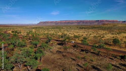 Aerial panning footage of a camper van traveling across beautiful El Questro, Kimberley, Kununurra, Western Australia photo
