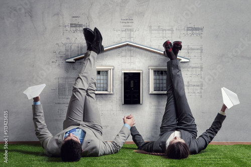 Couple of businessmen relaxing with their legs up on wall