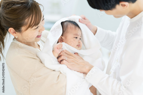 赤ちゃんをバスタオルで包むカップル