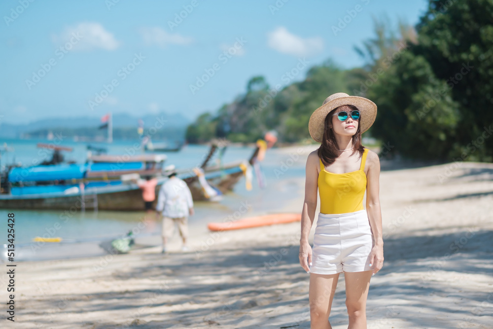 Woman tourist in yellow swimsuit and hat, happy traveler at Paradise beach on Islands. destination, wanderlust, Asia Travel, tropical summer, vacation and holiday concept Woman tourist in yellow swimsuit and hat, happy traveler at Paradise beach on Islands. destination, wanderlust, Asia Travel, tropical summer, vacation and holiday concept