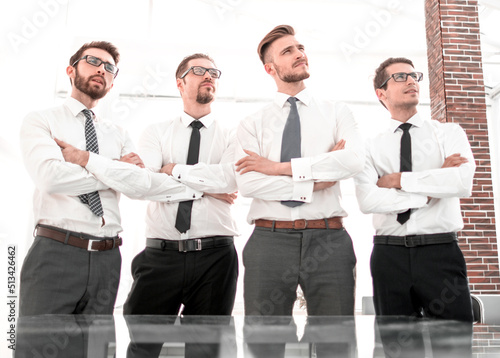 group of employees standing in an office and looking at a copy space