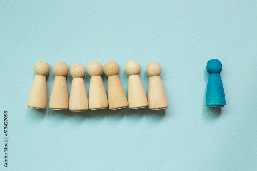 Majority vs minority concept. Wooden human figure on blue background