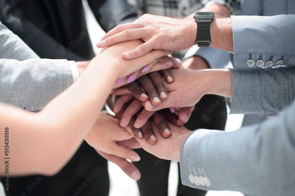 group of people in the office folded their hands together group of people in the office folded their hands together