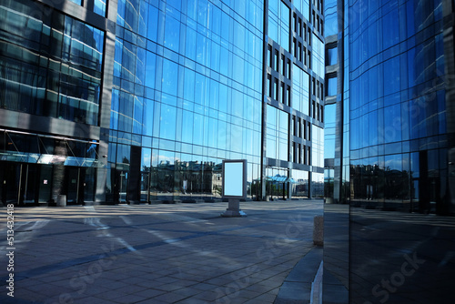 Offices building exterior in summer sunny day. Blue sky had been reflected in the glass of windows.