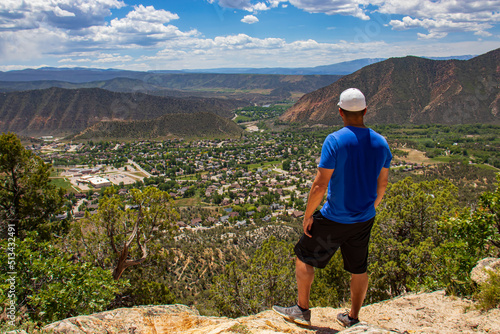 Man at the top of mountain feeling accomplished and free