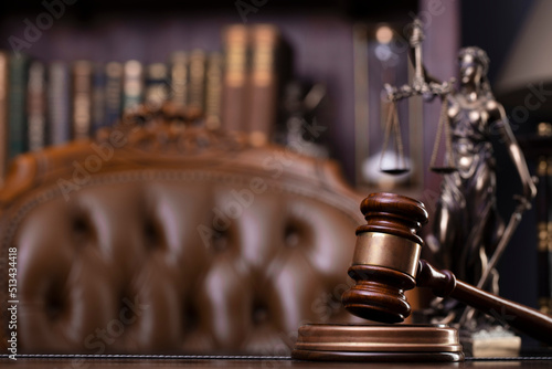 Judge office. Themis sculpture and gavel on the judge desk. Book shelf and judge chair in the background.