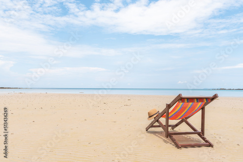 Empty beach chair on the beautiful sand beach under the clear blue sky