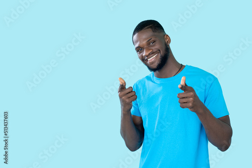 Offer advice. Hey you gesture. Good idea. Happy approving man pointing fingers to camera isolated on blue empty space studio background.