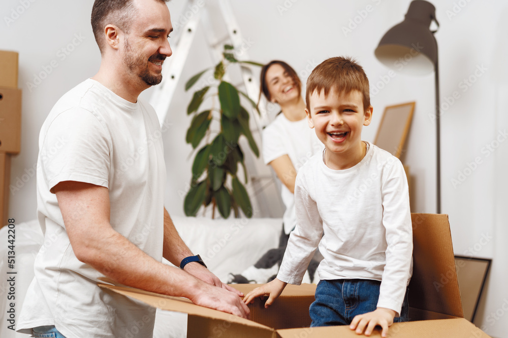 Parents and son packing boxes and moving into a new home Parents and son packing boxes and moving into a new home