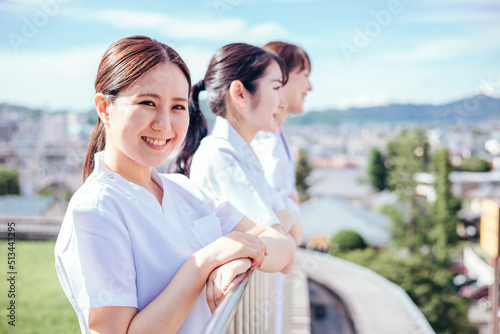 病院の屋上にいる白衣姿の医者と看護師（カメラ目線・笑顔）
 photo