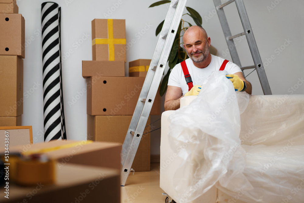 Leinwandbild Motiv - fotofabrika : Man mover in uniiform packing sofa for relocation