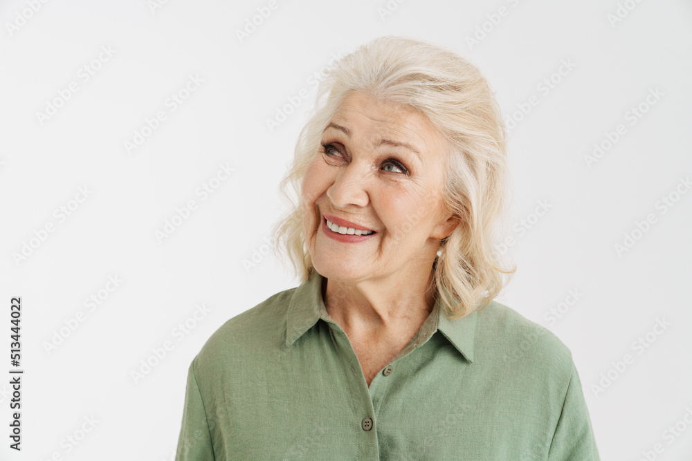 Grey senior woman in shirt smiling and looking aside Grey senior woman in shirt smiling and looking aside