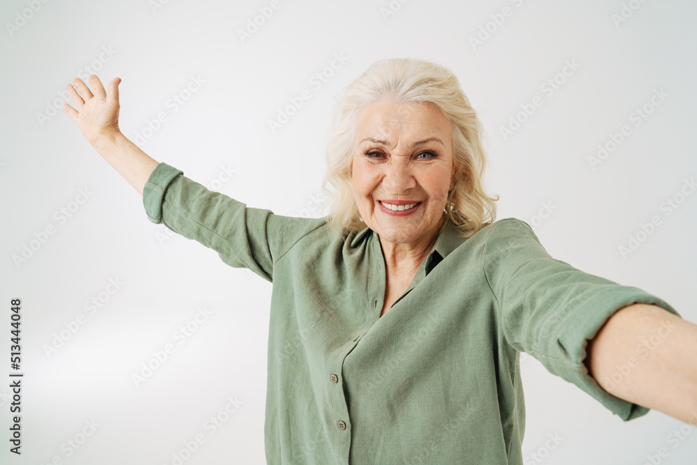 Grey senior woman showing copyspace while taking selfie photo Grey senior woman showing copyspace while taking selfie photo