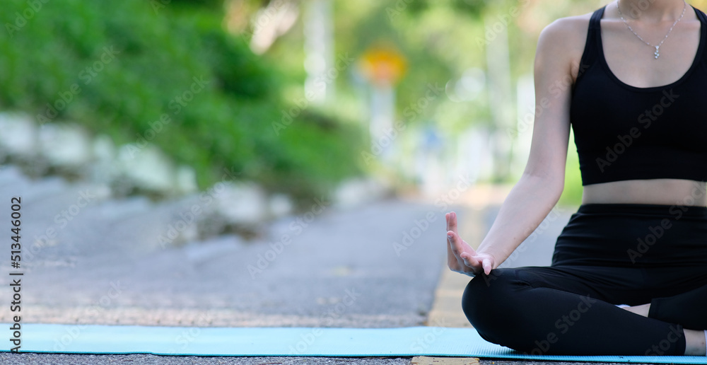 Woman doing yoga in the park and yoga relaxing in nature concept,Yoga outdoor. Happy woman doing yoga exercises, meditate in the park. Yoga meditation in nature. Concept of healthy lifestyle