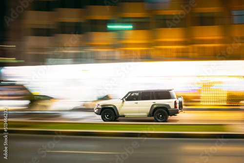 White SUV Car Fast Moving In City Street. Motion Blur Background.