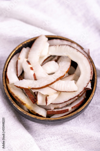 Dried coconut slices. Sliced dry coconut on a white background. Sun-dried fruit. close up