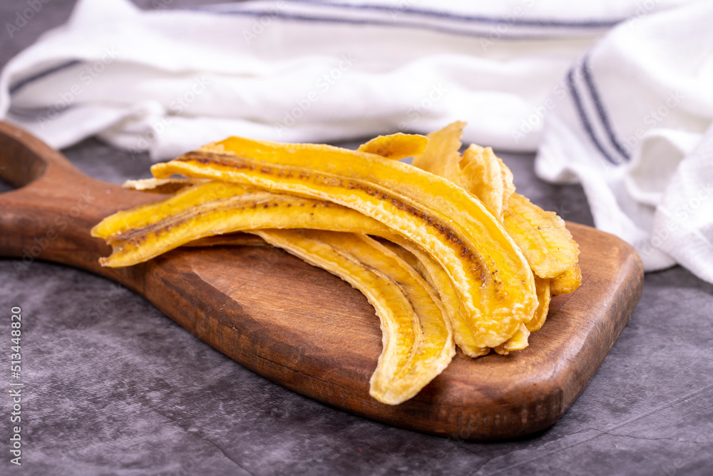 Dried banana slices. Sliced dried banana on a dark background. Sun-dried fruit. close up Dried banana slices. Sliced dried banana on a dark background. Sun-dried fruit. close up