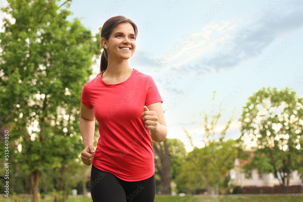 Young woman jogging around park in morning. Space for text Young woman jogging around park in morning. Space for text