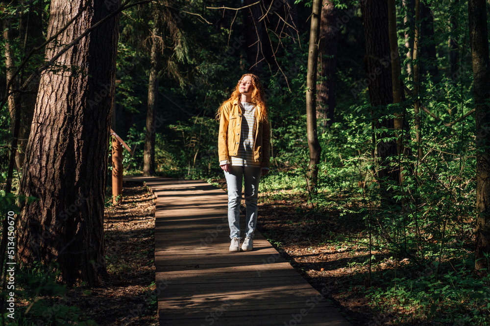 Young woman with eyes closed walking on footpath in forest Young woman with eyes closed walking on footpath in forest