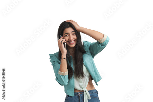 Young Venezuelan woman talking on the smartphone and laughing with her hand on the head. Isolated over white background.