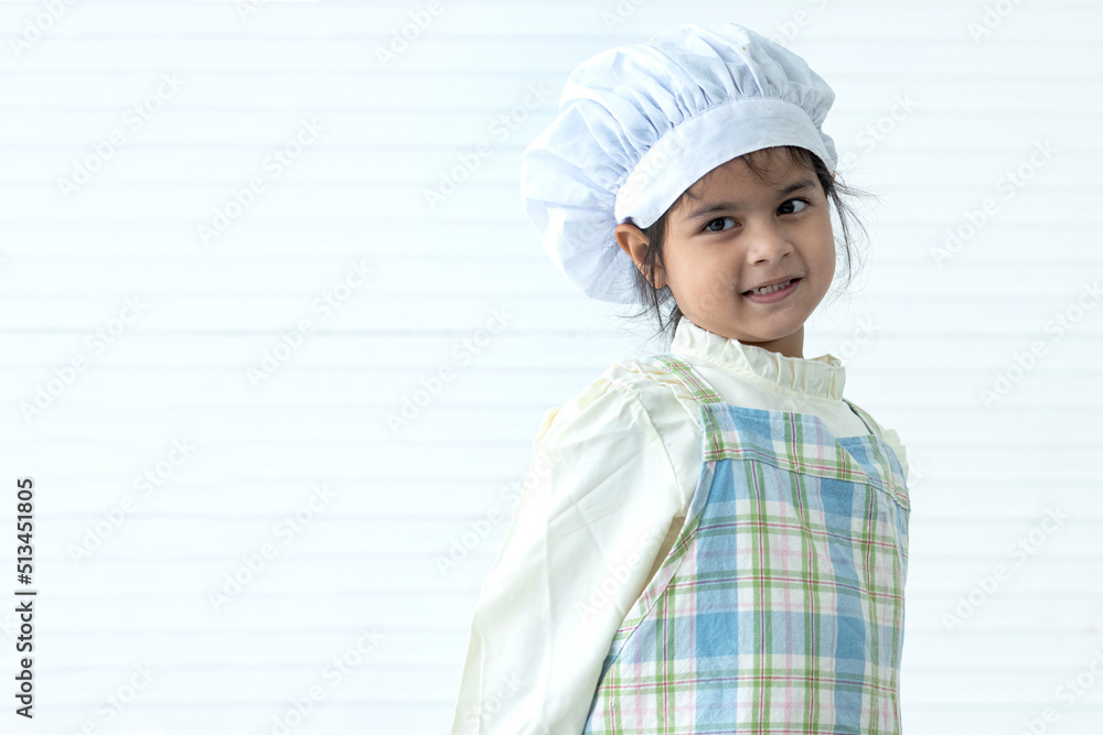 Close up portrait of adorable cheerful emotion facial girl, wearing chef's hat and apron isolate on white background Close up portrait of adorable cheerful emotion facial girl, wearing chef's hat and apron isolate on white background