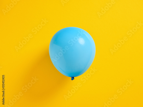 Fotobehang Blue inflated balloon on yellow background.