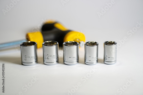 Small torque wrench with hex socket sizes 9mm, 10mm, 11mm, 12mm and 13mm. Torque wrench and various nuts photo