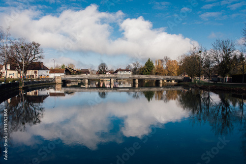 Les reflets des nuages dans une rivière traversant un village français. Une rivière dans un village avec un ciel nuageux et des reflets de nuages Un paysage bucolique.