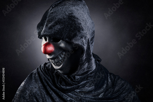 Fotografie, Obraz Scary clown showing his teeth over dark misty background