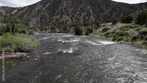 Drone Flying over River Rocky Mountains 4K features aerial from a drone flying about a river near Canyon City Colorado when birds start to swirl around and attack the drone.