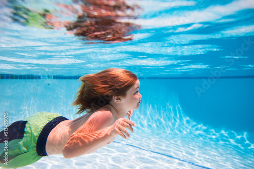 Underwater. Child in the swimming pool. Cute kid boy swimming in pool under water. Kids beach fun.