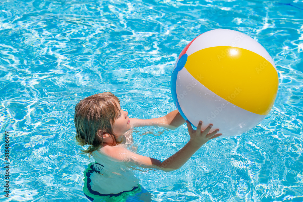 Boy kid swimming and playing in a pool. Child playing in swim pool. Summer vacation concept. Summer kids portrait.