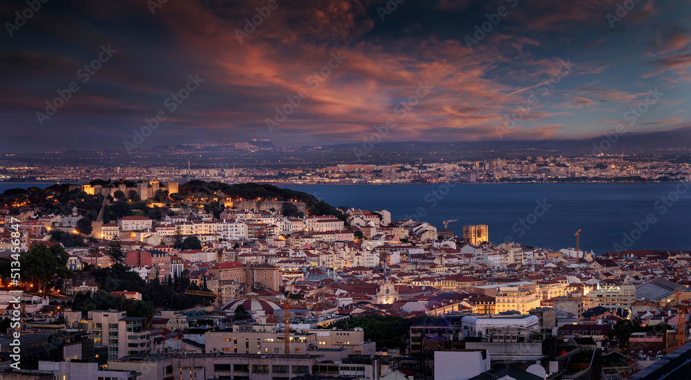 Elevated view of the illuminated cityscape of Lisbon, Portugal, with Sao Jorge Castle and the Alfama district