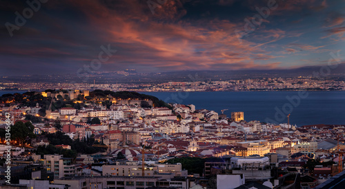 Elevated view of the illuminated cityscape of Lisbon, Portugal, with Sao Jorge Castle and the Alfama district