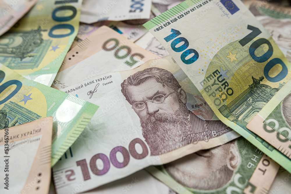 Top view of various euro and Ukrainian hryvnia banknotes on a spacious table. Top view of various euro and Ukrainian hryvnia banknotes on a spacious table.