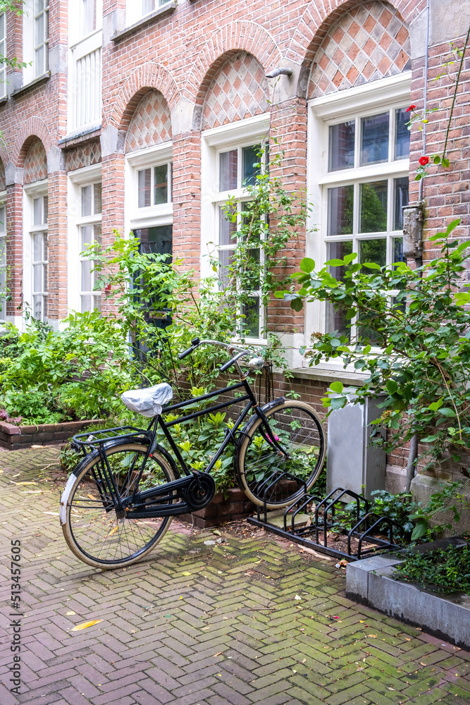 Bicycle parked in front of a red brick building, Amsterdam city neighborhood. Holland Netherlands.