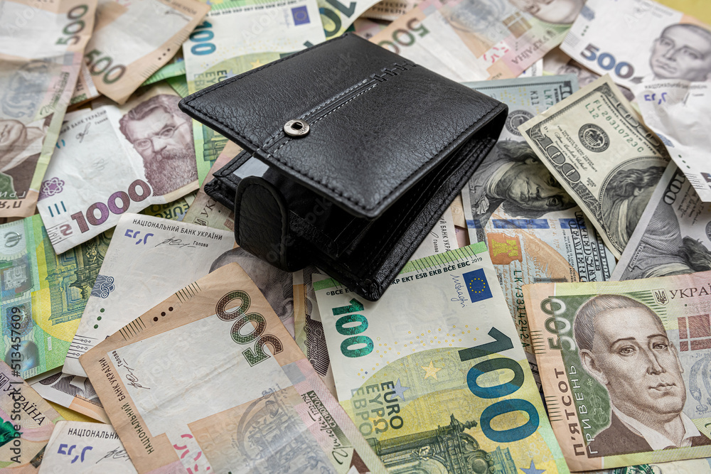 many euro hryvnia banknotes lie on the table next to a wallet with money and a calculator table many euro hryvnia banknotes lie on the table next to a wallet with money and a calculator table