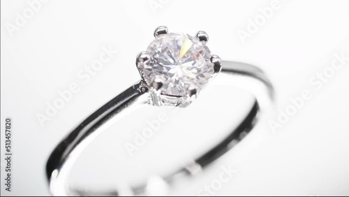Engagement diamond ring rotating on black background. Traditional piece of jewelry, macro shot. photo